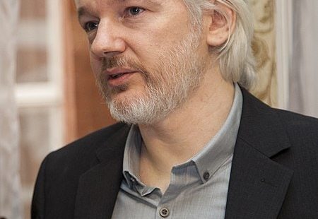 "Assange behind glass."